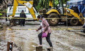 Mulher atravessa uma estrada inundada em El Salvador, depois que a tempestade tropical Amanda causou um deslizamento de terra