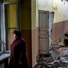 سيدة تقف في مدرسة مهجورة تضررت بعد سقوط قذيفة،  في كراسنوهوريفكا ، دونيتسك أوبلاست ، أوكرانيا. (من الأرشيف)