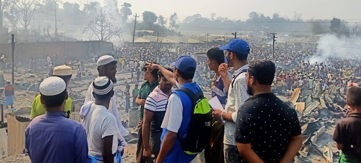 موظفو المنظمة الدولية للهجرة في مخيم كوتوبالونغ للاجئين في بنغلاديش. وفي الخلفية، عشرات الآلاف من اللاجئين الذين شردوا بعد الحريق.