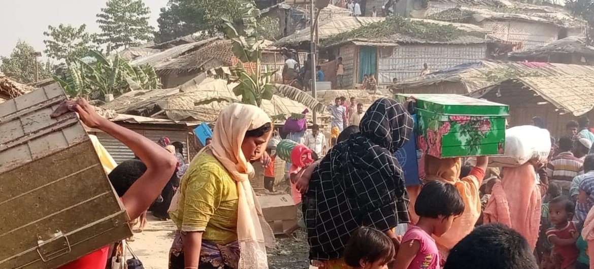 Refugiados rohingya afetados pelo incêndio evacuando com seus pertences
