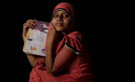 A fourteen year-old Rohingya refugee holds her favorite book of poetry at a refugee camp in Cox's Bazaar, Bangladesh.