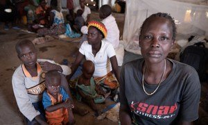En République démocratique du Congo, Jeanette Buse Lasi, veuve et mère de quatre enfants, est assise avec ses enfants dans un abri communal dans un camp de personnes déplacées à Bunia.
