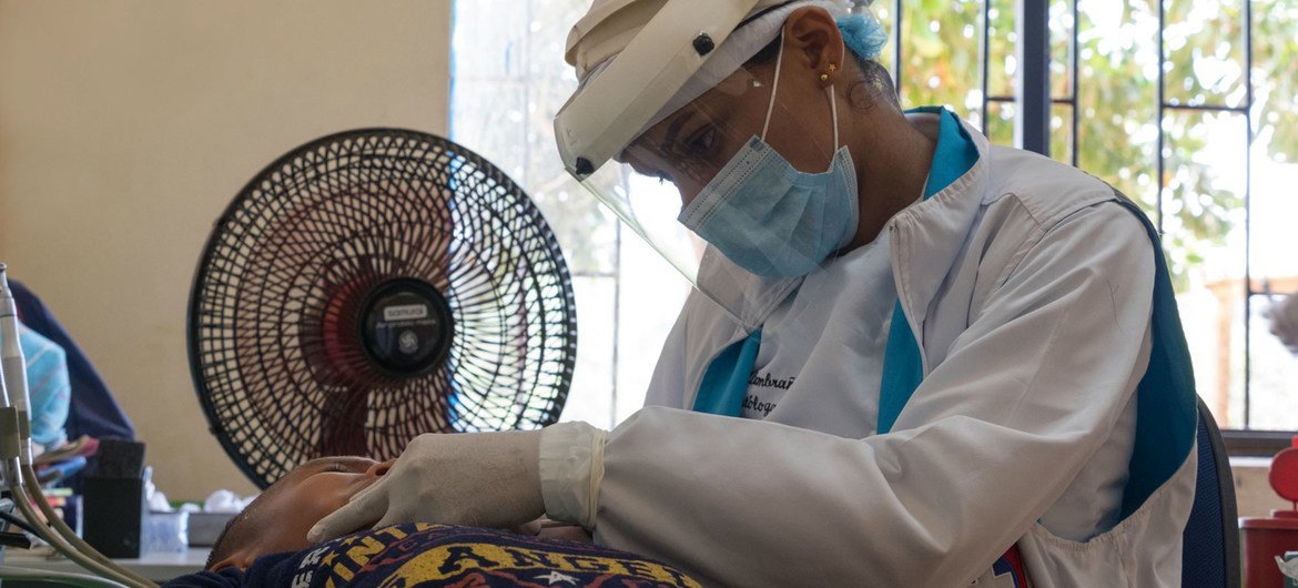 Trabajadora de salud revisando a un niño colombiano durante la pandemia de COVID-19.