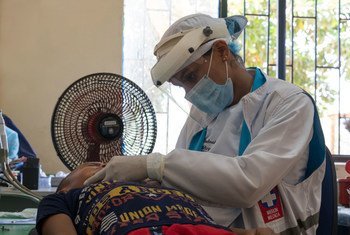 Trabajador de salud revisando a un niño colombiano durante la pandemia de COVID-19.