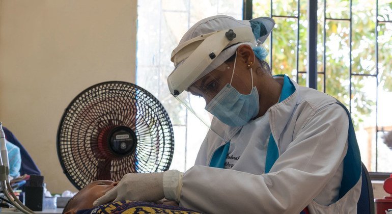 Trabajadora de salud revisando a un niño colombiano durante la pandemia de COVID-19.