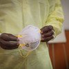 A health worker in Brazzaville in the Republic of the Congo puts on clothing to protect against the coronavirus.
