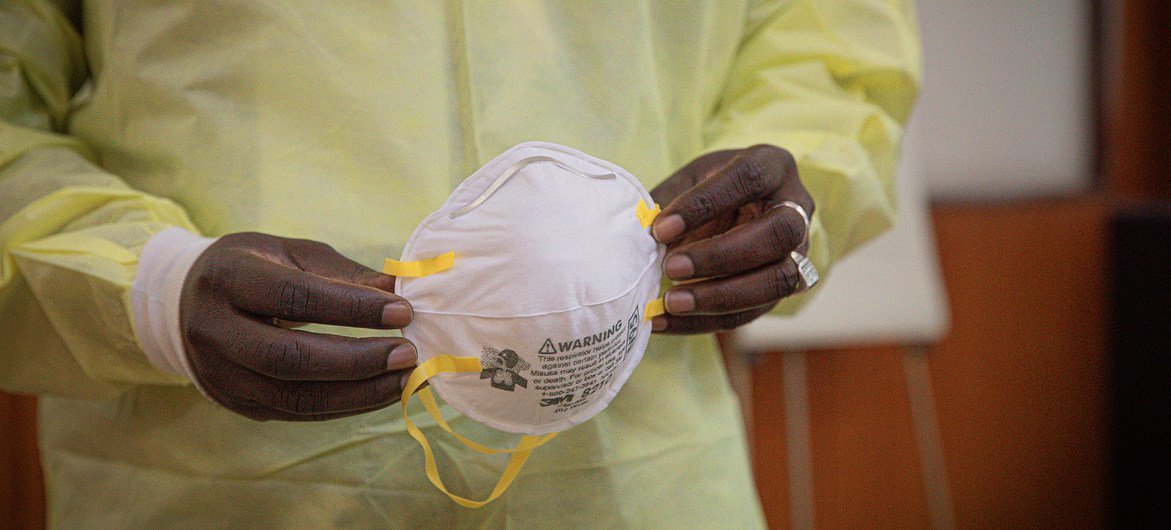 कॉंगो लोकतांत्रिक गणराज्य में एक स्वास्थ्यकर्मी मास्क पहनने के लिए तैयार हो रहा है.