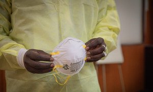 A health worker in Brazzaville in the Republic of the Congo puts on clothing to protect against the coronavirus.