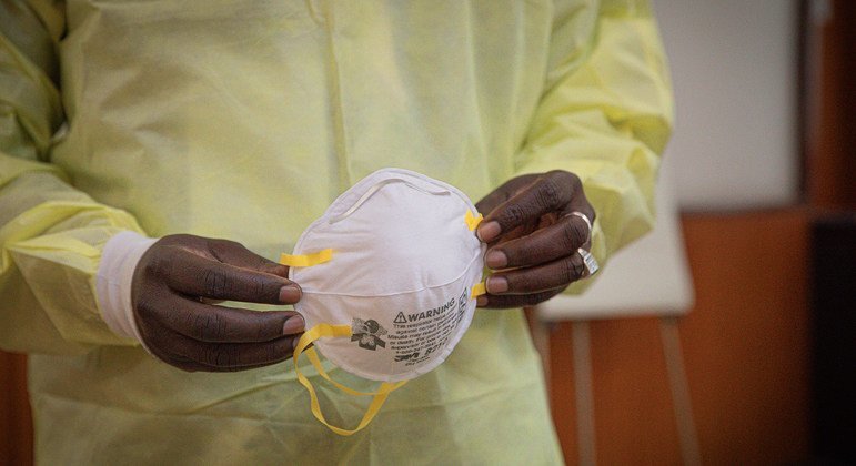 कॉंगो लोकतांत्रिक गणराज्य में एक स्वास्थ्यकर्मी मास्क पहनने के लिए तैयार हो रहा है.