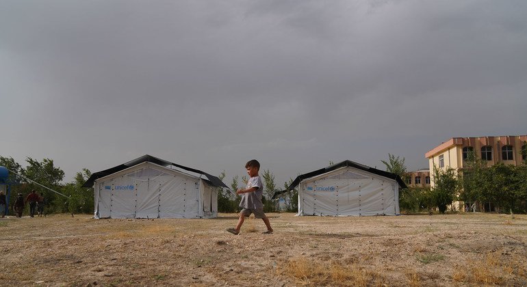 Uma criança caminha por um campo temporário montado em Cabul depois que sua família foi deslocada devido à insegurança em todo o Afeganistão