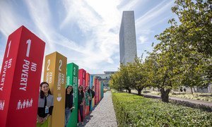 Young people line up along side a display at UN headquarters in New York representing the 17 Sustainable Development Goals .