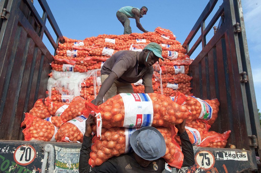 Un hombre descarga un saco de patatas de un camión en Bámako, en Malí.