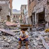شاب يمني يجلس على ركام منازل دمرتها الحرب.