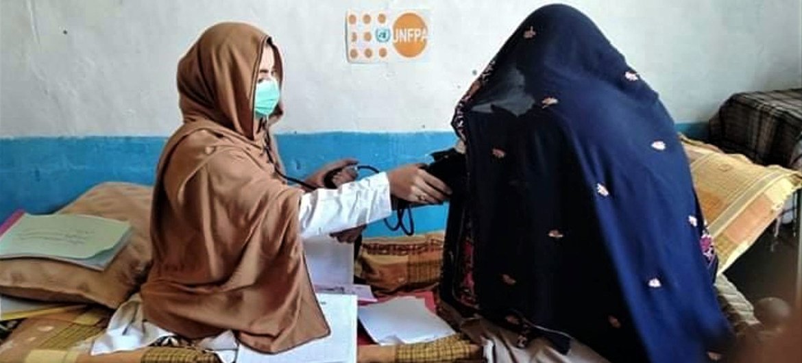 Une nouvelle mère est examinée par une sage-femme de l'équipe de santé mobile en Afghanistan. 