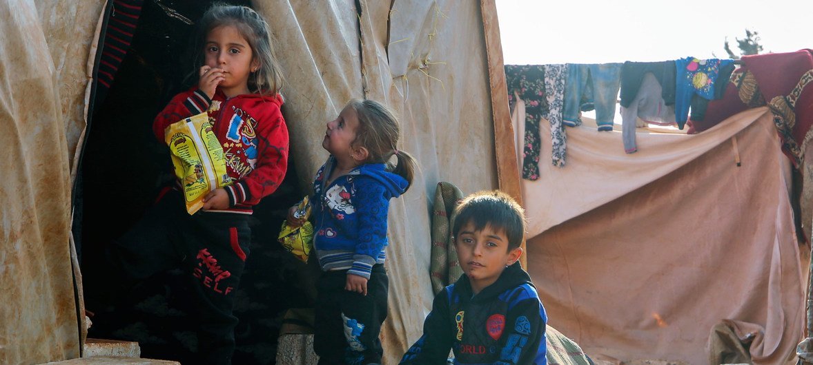 Crianças se abrigam do frio cem um assentamento informal em Killi, na Síria, perto da fronteira com a Turquia.