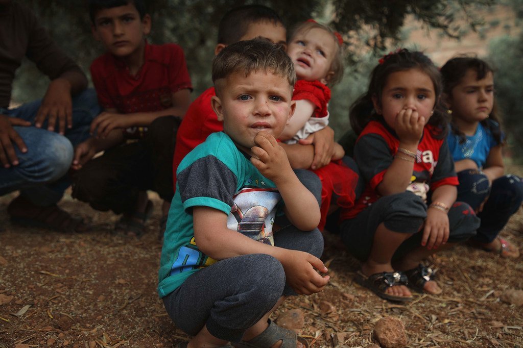 أطفال يستريحون تحت شجرة في سوريا. نصبت أسرهم مخيمات مؤقتة في بلدة عقربات، على بعد 45 كم شمال مدينة إدلب، بالقرب من الحدود التركية.