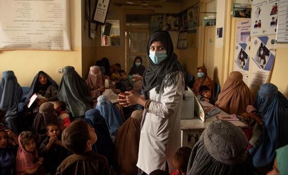 在阿富汗坎大哈举行的营养宣传会议上，一名营养护士与聚集在儿童基金会支持的诊所的妇女交谈。