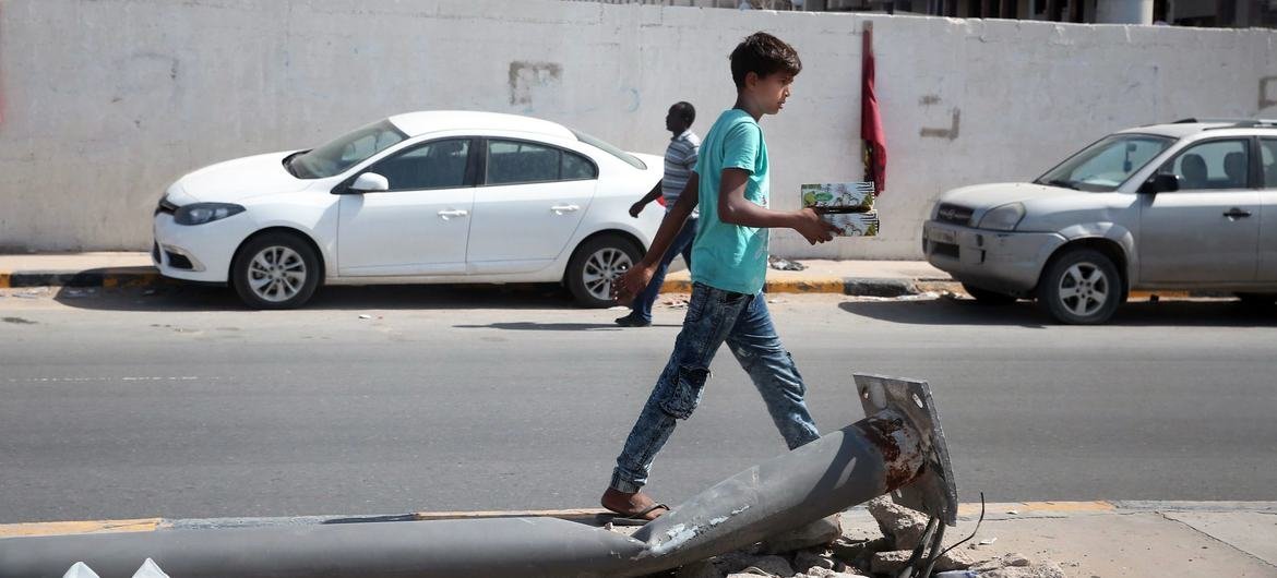 Boy walks down   a thoroughfare  successful  Tripoli, Libya.