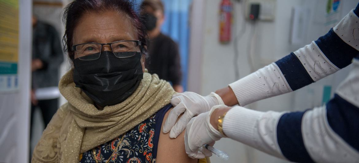 سيدة في السبعين من عمرها وهي تتلقى الجرعة الثالثة المعززة في ديمابور، الهند.