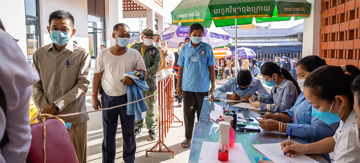 أشخاص يقفون في الصف للحصول على جرعة كوفيد-19 المعززة في أحد مستشفيات كمبوديا.
