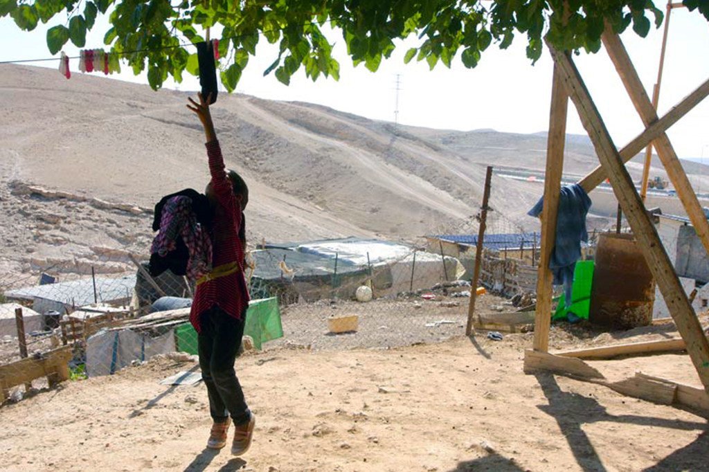 خلف هذه الصبية الفلسطينية التي تقوم بأعمال منزلية، منطقة محظورة على الفلسطينيين