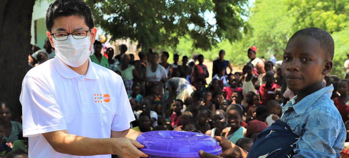 UNFPA Malavi Temsilci Yardımcısı Masaki Watabe, Sekeni İlköğretim Okulu Kampında haysiyet kitlerinin dağıtımına yardım ediyor 