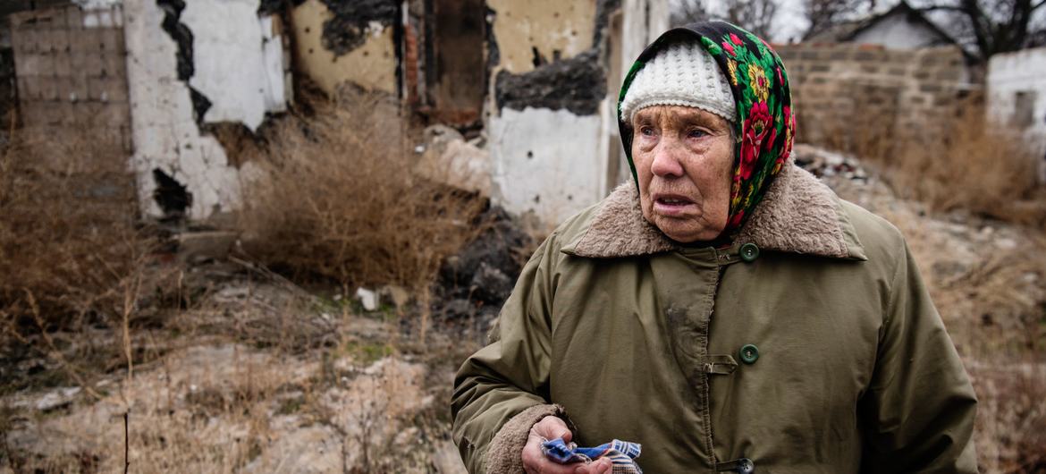यूक्रेन में एक महिला, अपने बनाए हुए गुलाब बाग़ीचे की तबाही को देखते हुए (फ़ाइल)