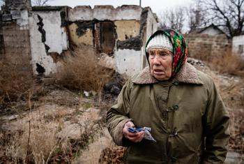 A woman stands in the middle of what used to be her rose garden in Ukraine. (file)