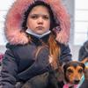 Une jeune Ukrainienne se repose avec son chien après être arrivée à Medyka, en Pologne, avec sa famille.