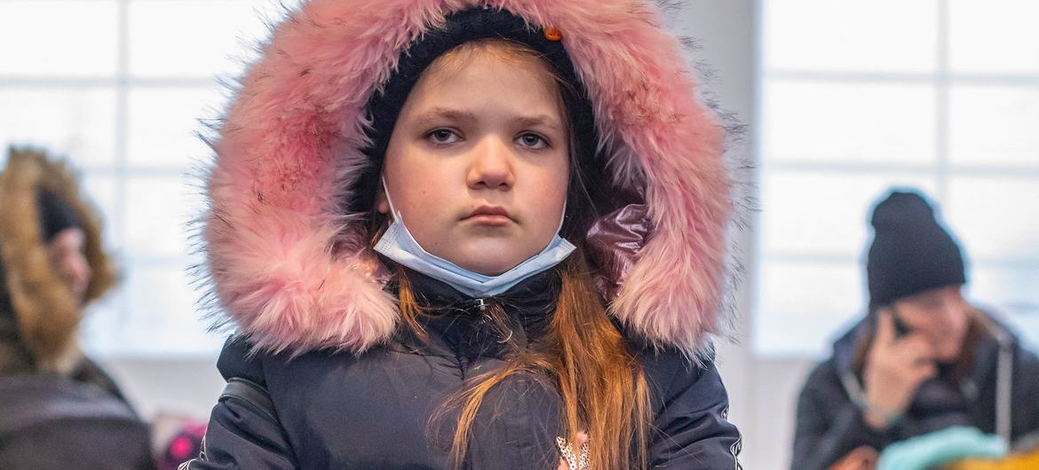 A young Ukrainian girl rests with her dog after arriving in Medyka, Poland, with her family.