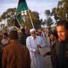 An old man holds Libya’s revived flag during a military graduation ceremony in the western city of Zawia. December 2011.