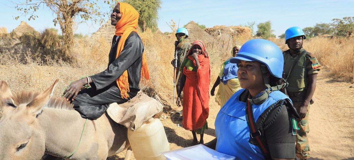 Peacekeepers from the African Union-UN Hybrid Operation in Darfur (UNAMID) provide protection to local women in Aurokuom village, Sudan.