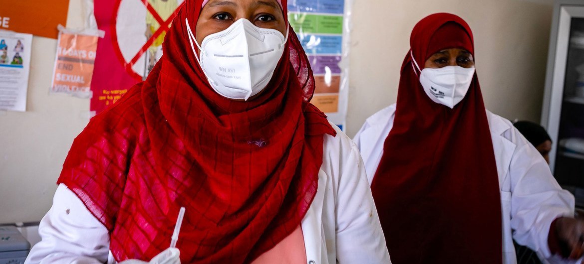 Una trabajadora de salud prepara la vacuna COVID-19 para administrársela a una colega en el hospital de Mogadishu, Somalia, en que trabajan.