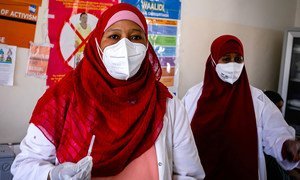 A health worker prepares to administer the COVID-19 vaccine to her colleague at a hospital in Mogadishu, Somalia.