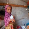 也门塔伊兹的一个境内流离失所者收容所里的一名三岁女孩在接受粮食署的粮食援助。