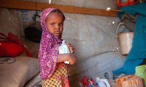 A three-year-old girl receives WFP food assistance at an IDP shelter in Taiz, Yemen.