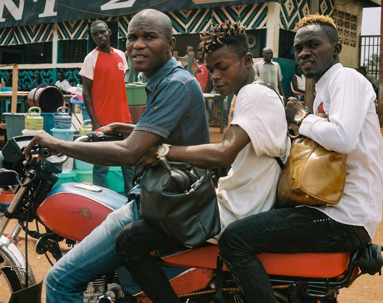 Kama anavyo onekana katika pikipiki, anabeba abiria jioni Bangui Jamhuri ya Afika ya Kati ili kuihudumia familia yake