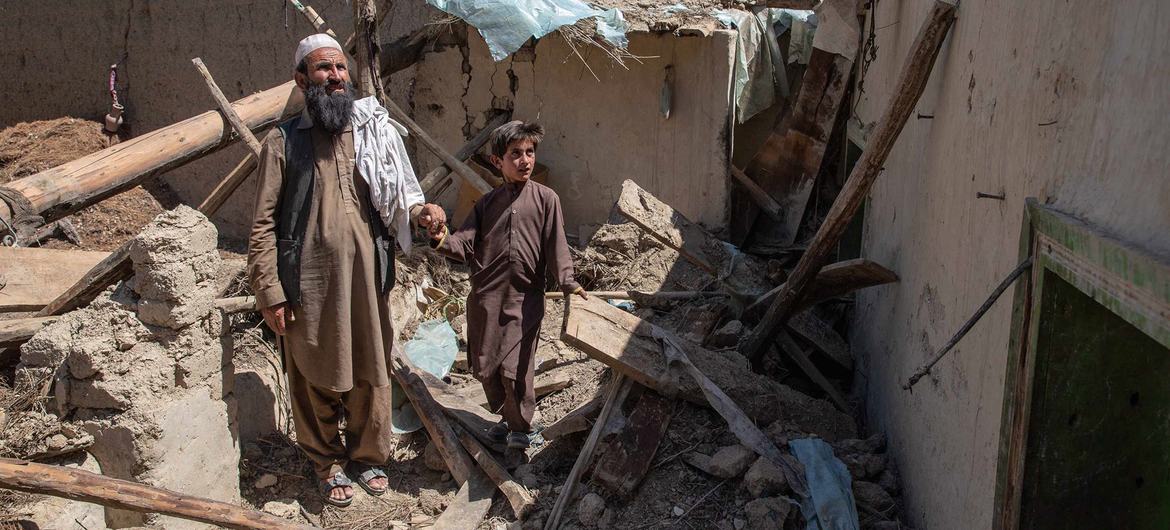 Un hombre y su hijo caminan entre las ruinas de su casa, destruida durante el terremoto en Afganistán.