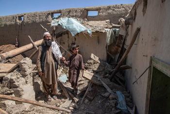 A father and son walk amidst the wreckage of their home, destroyed during the earthquake whick struck Paktika Province, Afghanistan.