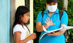 An eleven-year-old girl in Ecuador receives a study guide during the COVID-19 pandemic when schools closed.