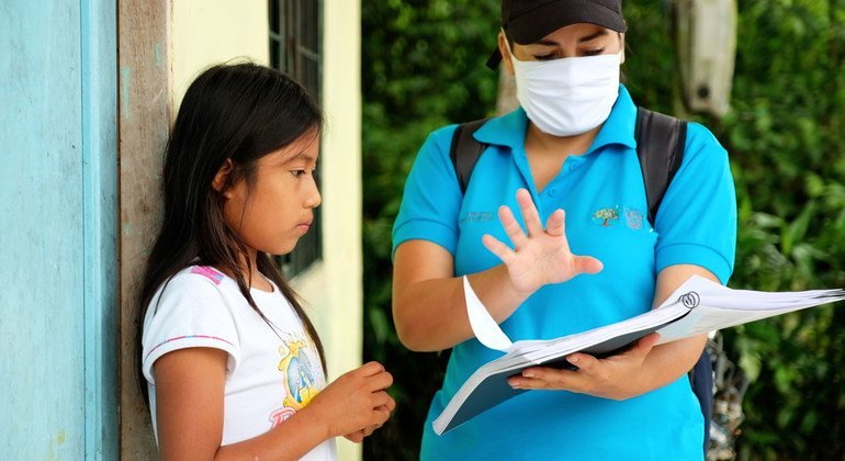 An eleven-year-old girl in Ecuador receives a study guide during the COVID-19 pandemic when schools closed.