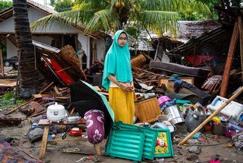 فتاة تقف خارج منزلها الذي انهار عندما ضرب تسونامي جاوة وسومطرة ، أكثر جزيرتين من حيث عدد السكان في إندونيسيا.