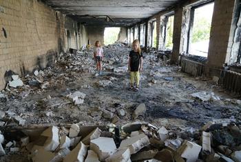 Unas amigas de ocho años en medio de los escombros de su escuela dañada en Buzova, Ucrania.