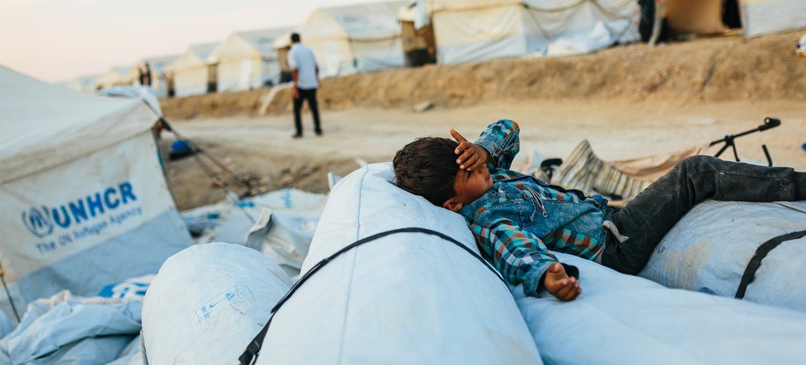 希腊莱斯沃斯岛难民营火灾后，一名来自阿富汗的男孩正在临时安置点内休息。