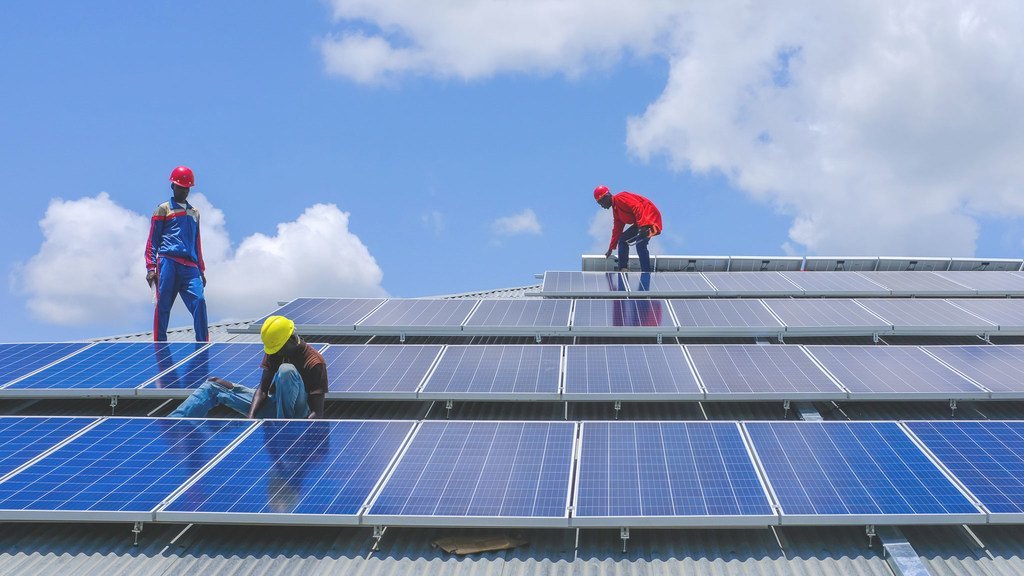 作为联合国开发计划署牵头的绿色翻新项目的一部分，技术人员在南苏丹拉贾夫的一所警察学院安装太阳能电池板。(2018年8月21日)