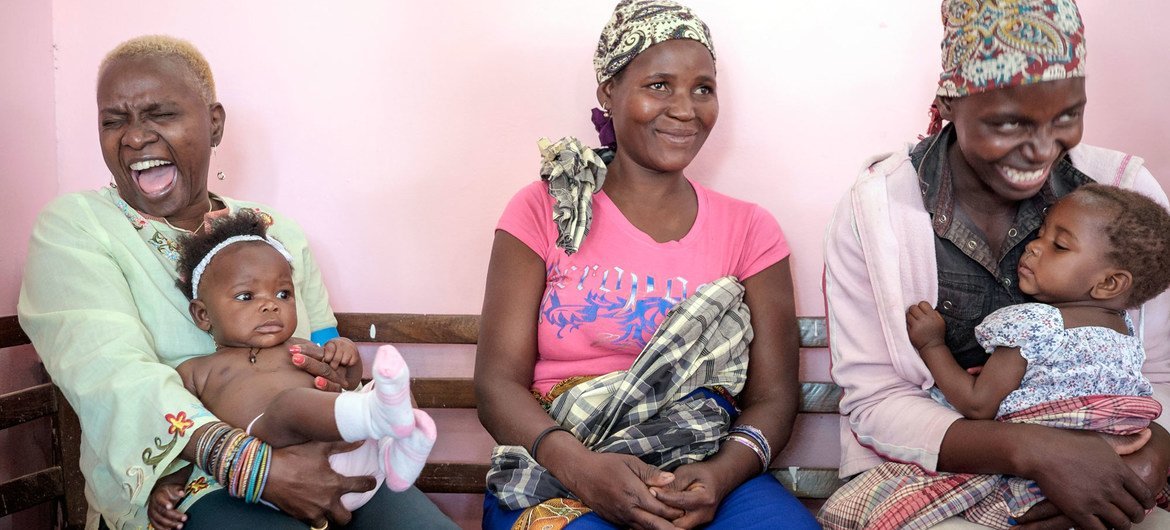 L'ambassadrice itinérante de l'UNICEF Angelique Kidjo (à l'extrême gauche) écoute des mères au Mozambique qui lui racontent leurs rêves pour leurs enfants.