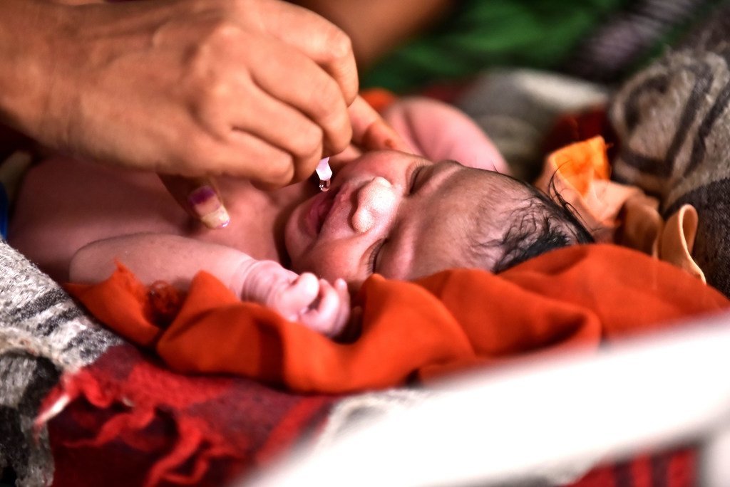 Un bébé se fait vacciner contre la polio au village de Maliwada en Inde
