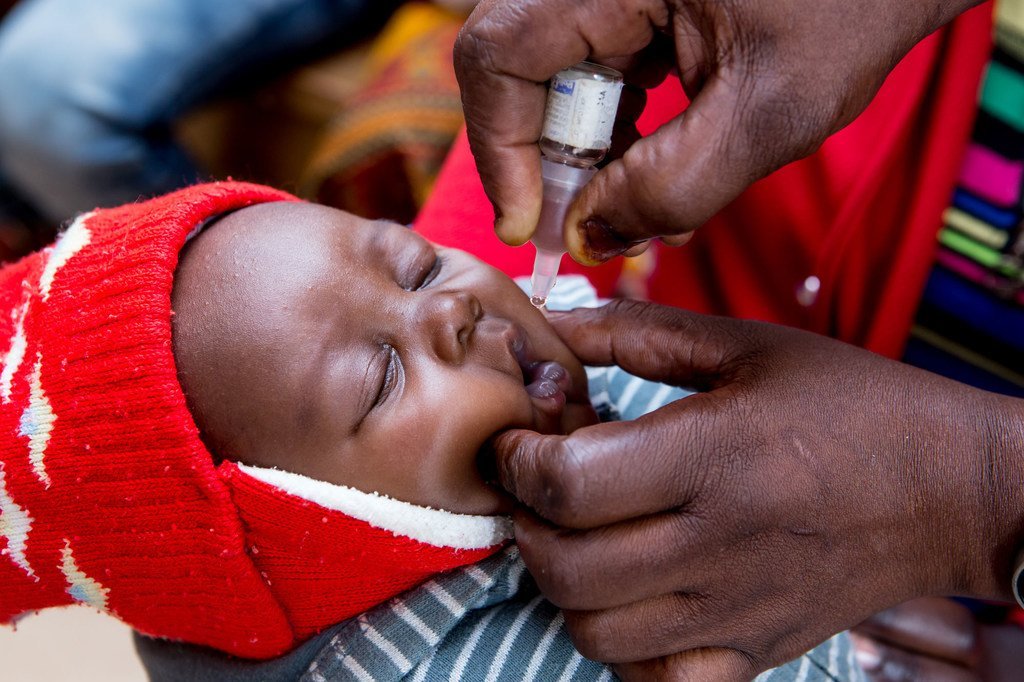 在赞比亚恩多拉的一间诊所，一名护士正在给一个婴儿口服脊髓灰质炎病毒疫苗（OPV）。
