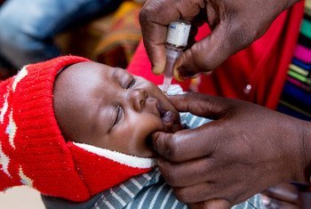 ज़ाम्बिया के न्दोला में नर्स एक बच्चे को वैक्सीन देते हुए.