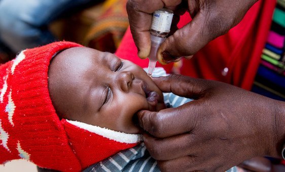 ممرضة تعطي لقاح فيروس شلل الأطفال لطفل عن طريق الفم لطفل في عيادة في زامبيا.